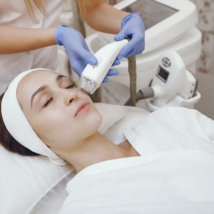 Cosmetologist use laser. Woman with cosmetologist. Lady in a beauty studio.